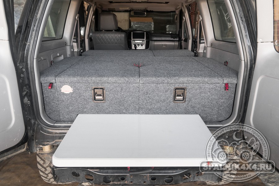 Toyota Land Cruiser 105 - автомобильный спальник с интегрированным столом и раскладываемыми элементами, прикрепленными к спинкам второго ряда сидений