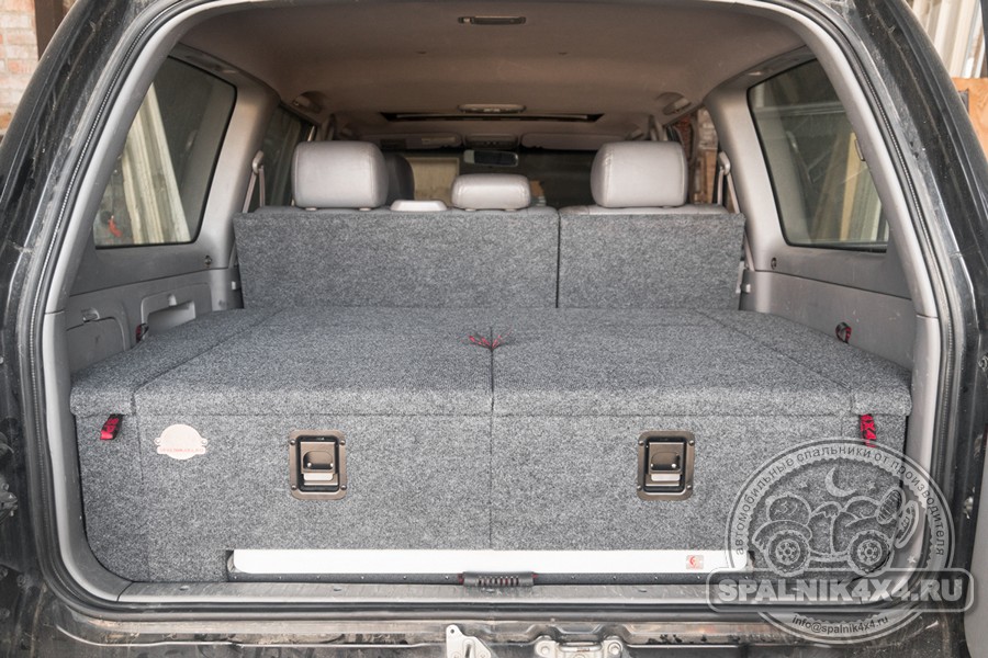 Toyota Land Cruiser 105 - автомобильный спальник с интегрированным столом и раскладываемыми элементами, прикрепленными к спинкам второго ряда сидений